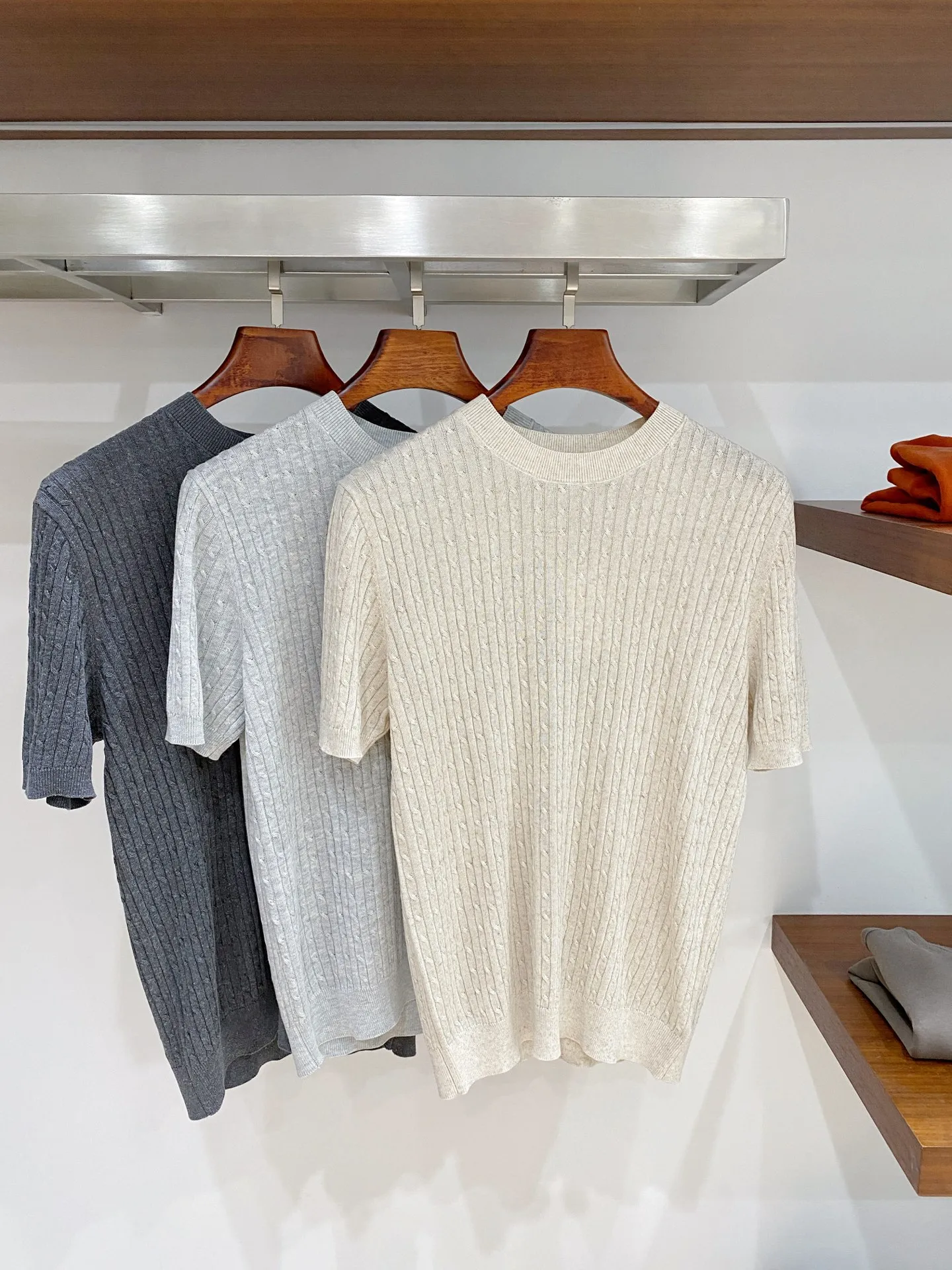 Loro Piana Vertical Twist Twist Round Neck Knitted Short Sleeve Fabric: High-count fine knitted yarns are selected, and the Classic three-dimensional cable knitting process is used to create a vertical twist texture. After multiple rounds of softening pre-treatment, the rough and itchy feeling of ordinary cable fabrics is eliminated, and it is soft and skin-friendly; The micro gaps formed by the knitting enhance the air circulation effect, and the spring and summer Breathable effect is outstanding, perspiration is not easy to stick to the back; The fabric texture has a natural matte texture, which is not easy to show signs of wear and shine. It has excellent toughness and is not prone to pilling and snagging for daily wear. It is a high-end old-money style knitted fabric with a rich sense of detail. Style and details: Optimized right-shoulder round-neck style, with dense ribbing at the neckline, excellent shaping effect, long-term wear and repeated washing, it is not easy to collapse the collar or become loose; short-sleeve cuffs are narrow ribbing, neatly cut, and the cuffs will not shift randomly when raising hands in daily life; the body adopts a moderate straight style, the vertical twist pattern visually elongates the body shape, cleverly modifies the waist and upper body contours, and is more tolerant to fatter figures; The ribbing at the hem is flat and gathered, and the wiring is precisely hidden. The entire piece abandons the conspicuous external logo and relies on the cable texture to present texture. The details are low-key and elegant, and it is suitable for various daily matching ideas. Color selection: Three low-saturated colors: soft oatmeal, light fog gray, and dark charcoal gray, suitable for commuting to work, holiday travel, and daily leisure travel. Style positioning: Italian Retro is for light business, elegant daily casual, and light luxury vacation wear. The shape is very inclusive and can be worn by both men and women. It has a high-end texture when worn alone. It can also reveal exquisite texture details when layered with a suit jacket, making it easy to create a textured outfit. Sizes:M-3XL